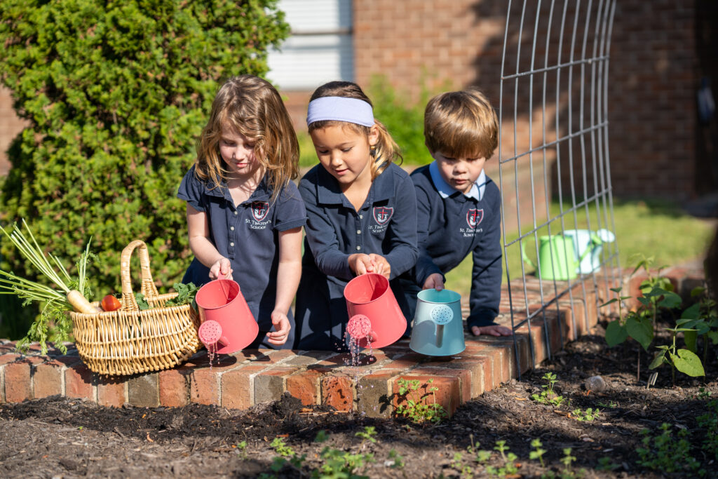 St. Timothy's Pre-Kindergarten and Kindergarten watering plants in the campus garden