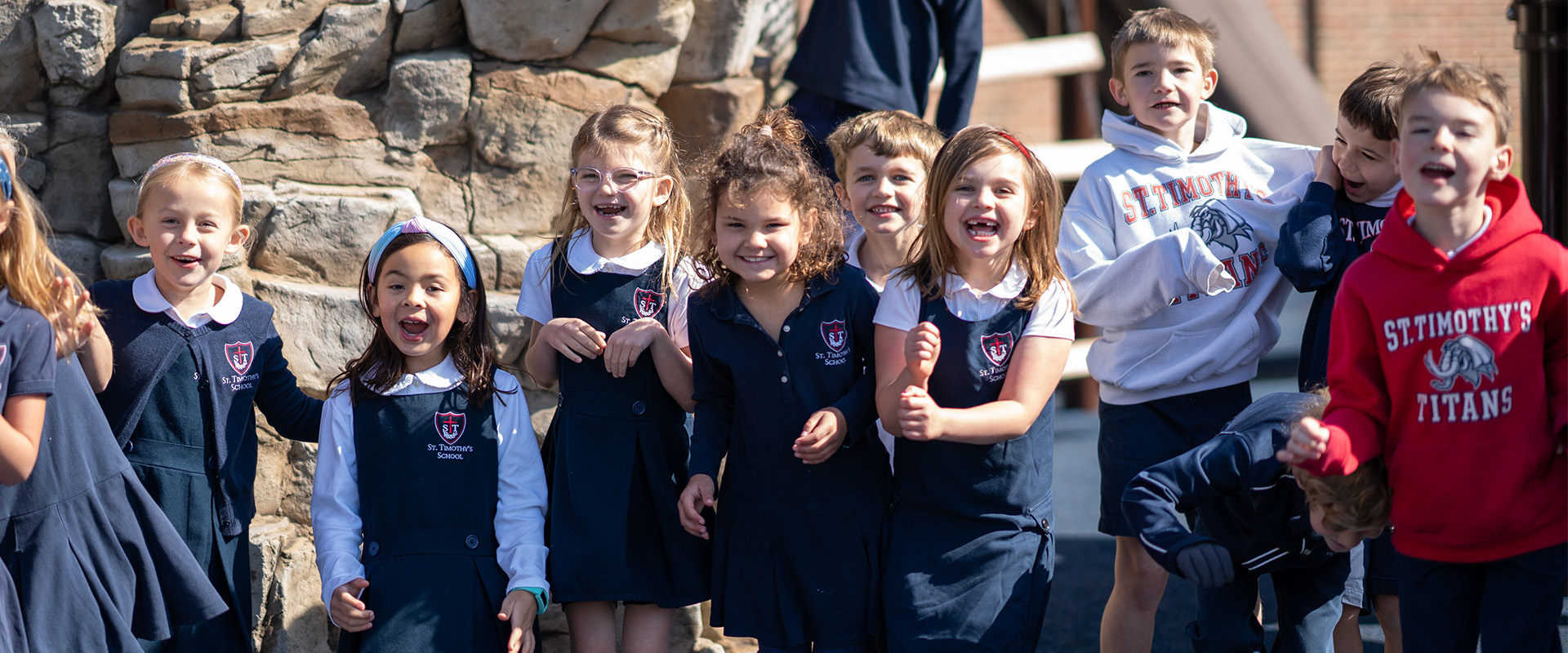 Group of St. Timothy's students smiling on the playground