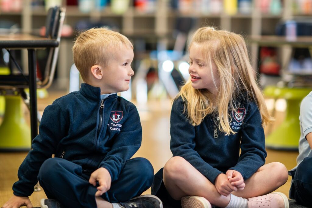 Two lower school students smiling in class