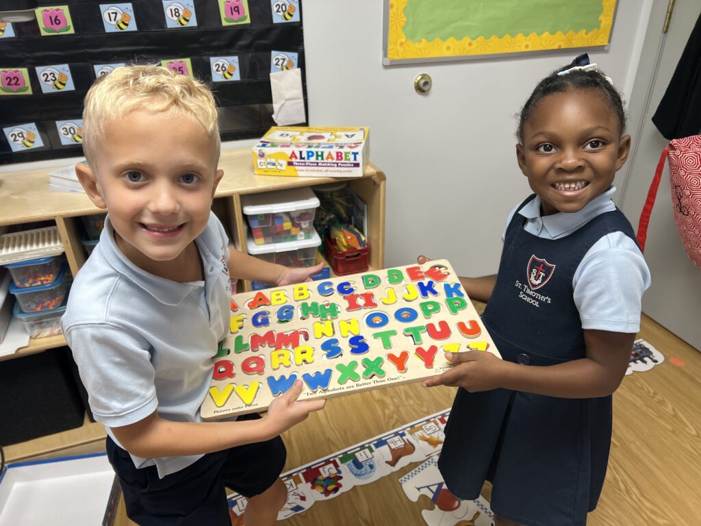 St. Timothy's School kindergarten students show off their completed letter puzzle.