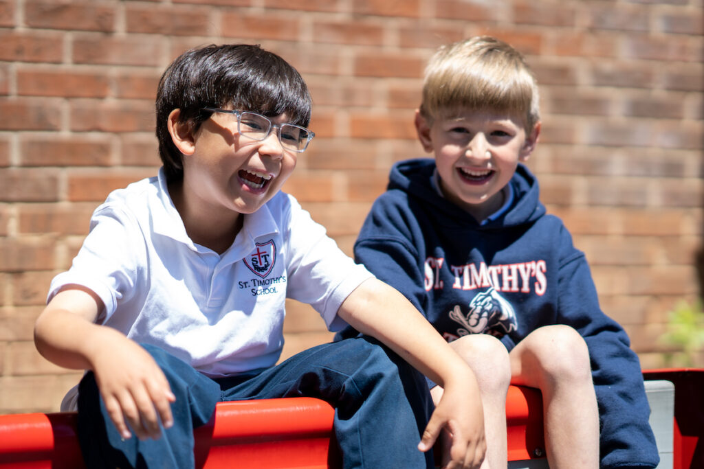 Two St. Timothy's students smiling and laughing during recess
