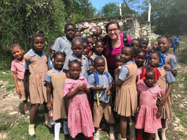 Volunteer posing with students from St. Timothees in Haiti